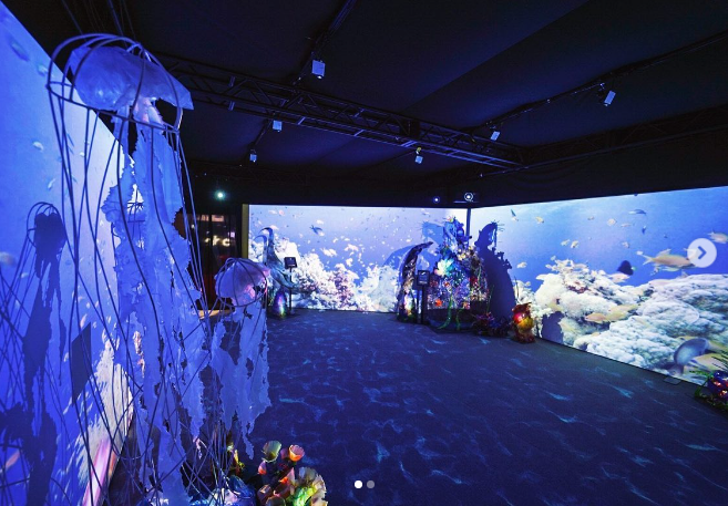 A still from the Beneath the Blue activation, showing ocean imagery in a large room.