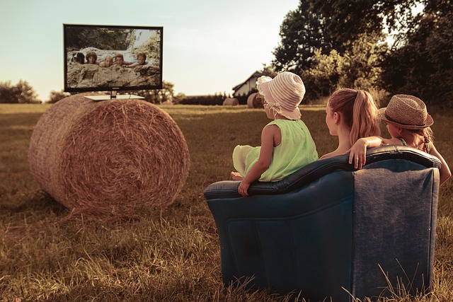 A family watching TV on a hay bale